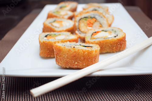 Rollitos de sushi japones con relleno de arroz y camaron sobre un plato blanco
