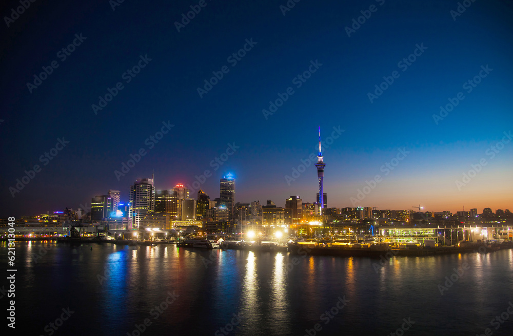 Night city of Auckland New Zealand. Glowing skyscrapers, bay and seaport of Auckland.