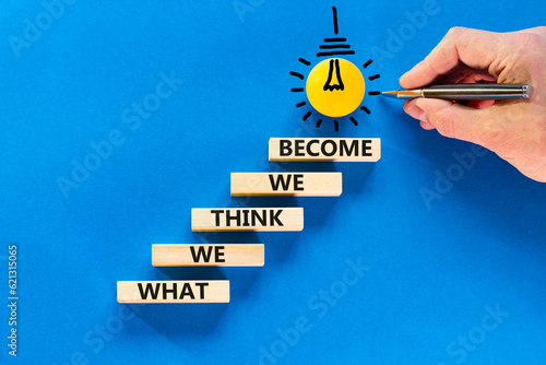 We become or think symbol. Concept word What we think We become on wooden block. Beautiful blue table blue background. Businessman hand. Business we become or think concept. Copy space.