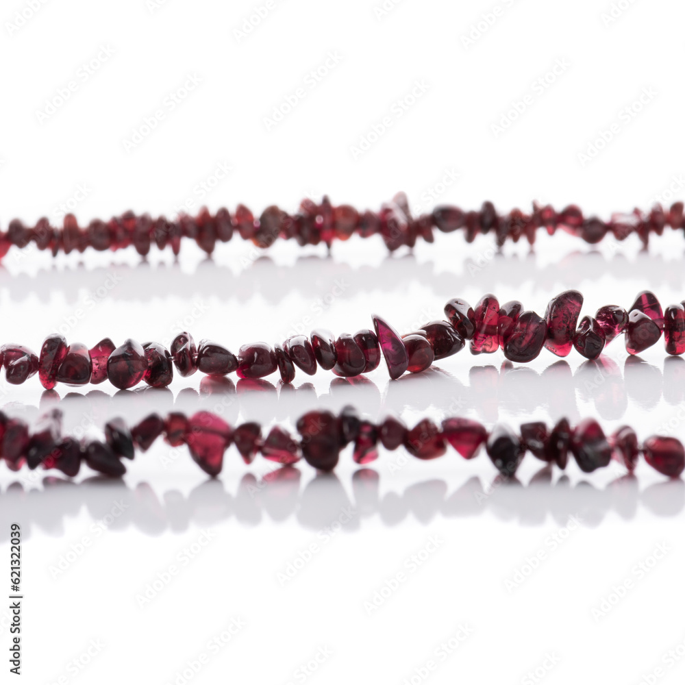 Strung garnet natural stones strings on white background. Energy crystals. Healing gemstones. Birthstones.