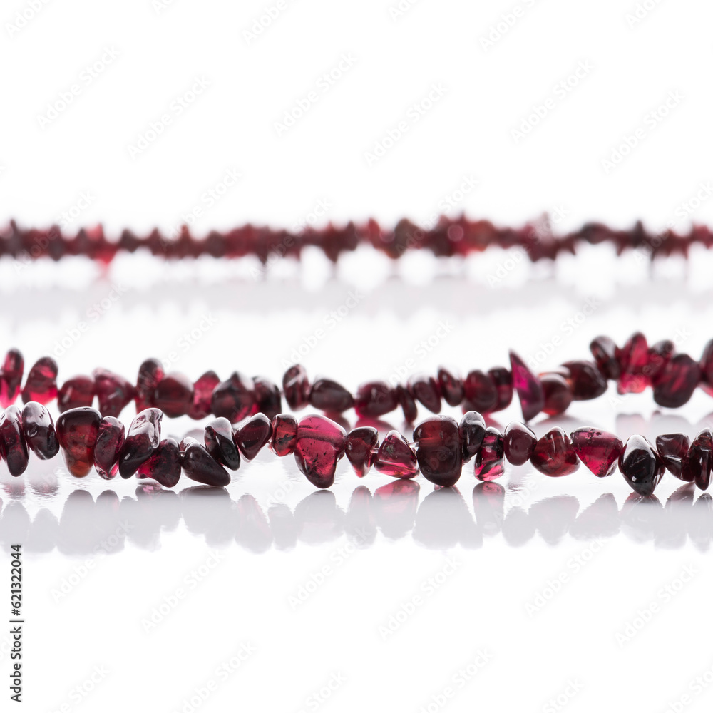 Strung garnet natural stone strings on white background. Energy crystals. Healing gemstones. Birthstones.