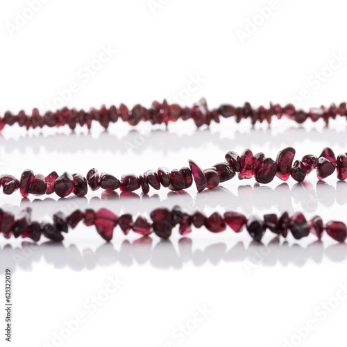 Obraz na płótnie Strung garnet natural stones strings on white background. Energy crystals. Healing gemstones. Birthstones. w salonie