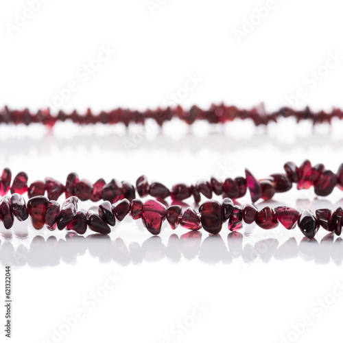Obraz na płótnie Strung garnet natural stone strings on white background. Energy crystals. Healing gemstones. Birthstones. w salonie