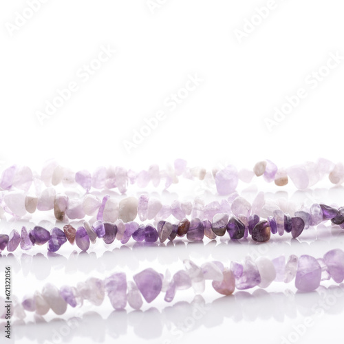 Obraz na płótnie Strung amethyst natural stone strings on white background. Energy crystals. Healing gemstones. Birthstones. w salonie