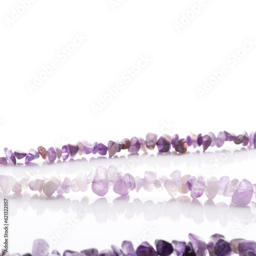 Obraz na płótnie Strung amethyst natural stone strings on white background. Energy crystals. Healing gemstones. Birthstones. w salonie