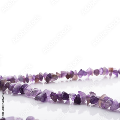 Obraz na płótnie Strung amethyst natural stone strings on white background. Energy crystals. Healing gemstones. Birthstones. w salonie