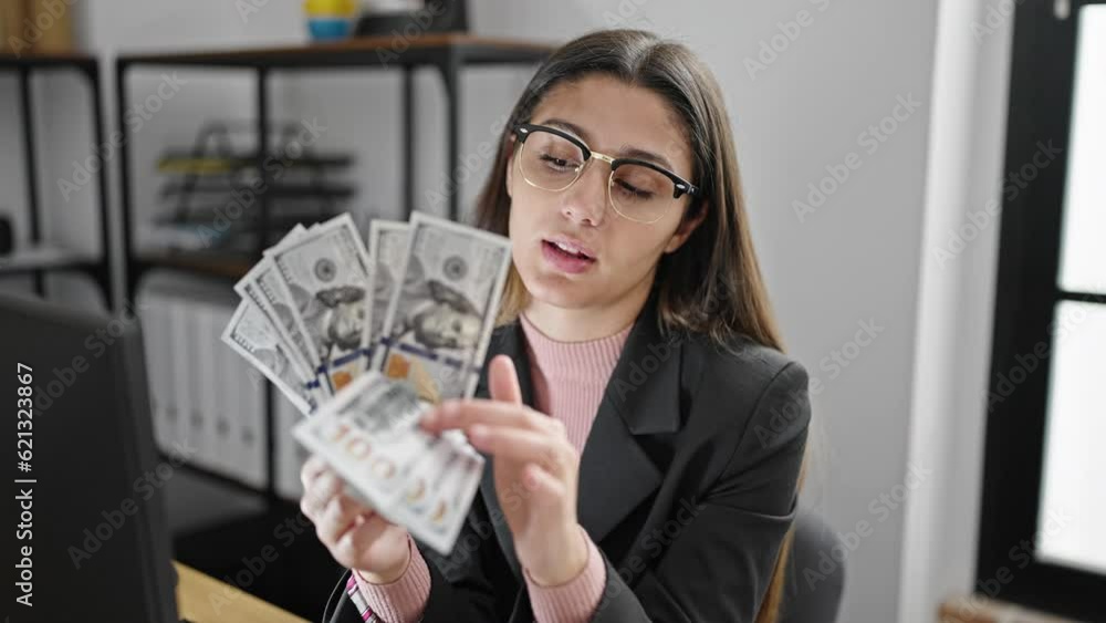 Young beautiful hispanic woman business worker sitting on table counting dollars at office Young beautiful hispanic woman business worker sitting on table counting dollars at office