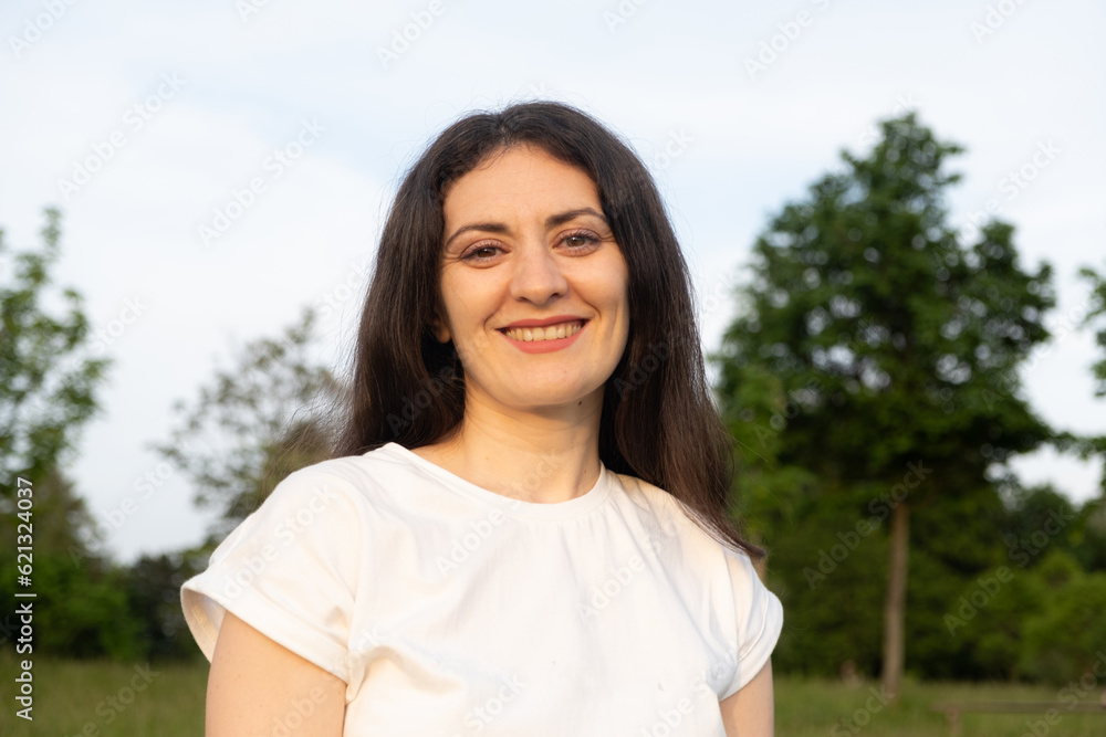 Portrait of a 35-year-old brunette woman looking at the camera smiling in nature. Portrait of a 35-year-old brunette woman looking at the camera smiling in nature.