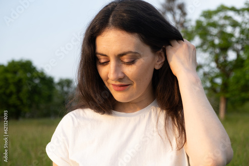 Dreamy pensive 35-year-old brunette woman in nature. The concept of unity with nature, feminine energy.