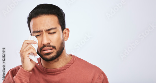 Crying, depression and sad asian man in studio with tissue, crisis or broken heart on grey background. Stress, mistake and face of male with tears for anxiety, trauma or bad news, fail or mourning