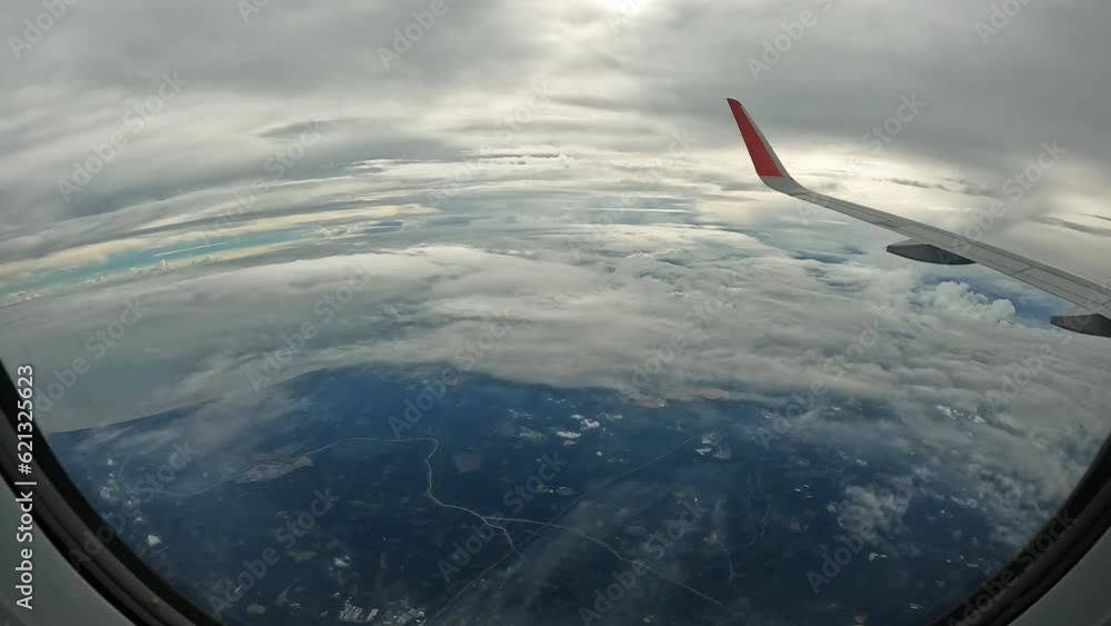 View from window of airplane flying high above lot of fluffy clouds. Timelapse of flight of aircraft high in sky, view from window of aircraft. Concept of travel, tourism, journey by plane. Cloudscape