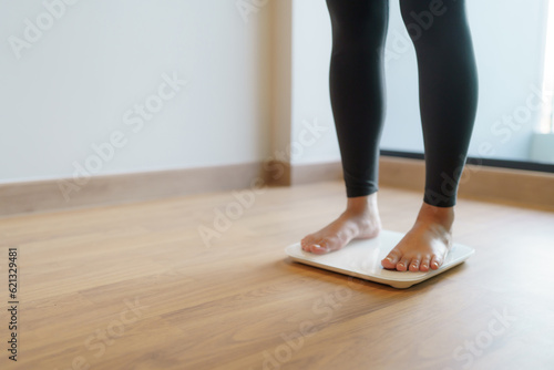 Lose weight. Fat diet and scale feet standing on electronic scales for weight control. Measurement instrument in kilogram for diet.