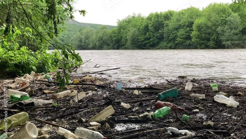 Plastic bottle waste collects on the side of a river contributing to river pollution and environmental damage - Bulgaria.