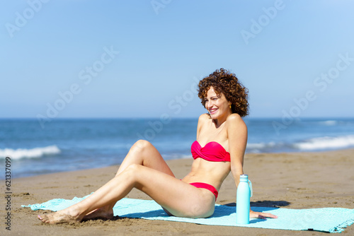 Happy woman in bikini on beach admiring view