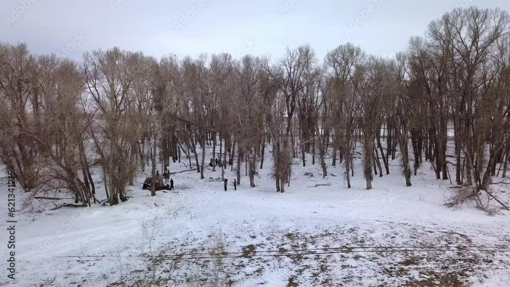 Aerial Panning Shot Of Bare Trees In Winter Forest Against Sky, Drone Flying Near Towards People On Snow - Billings, Montana Aerial Panning Shot Of Bare Trees In Winter Forest Against Sky, Drone Flying Near Towards People On Snow - Billings, Montana