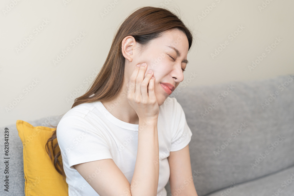Closing eyes asian young woman hand touching cheek, face expression from toothache, tooth decay or sensitivity, Having tooth or teeth problem or inflammation, suffering from health. Sensitive teeth. Closing eyes asian young woman hand touching cheek, face expression from toothache, tooth decay or sensitivity, Having tooth or teeth problem or inflammation, suffering from health. Sensitive teeth.