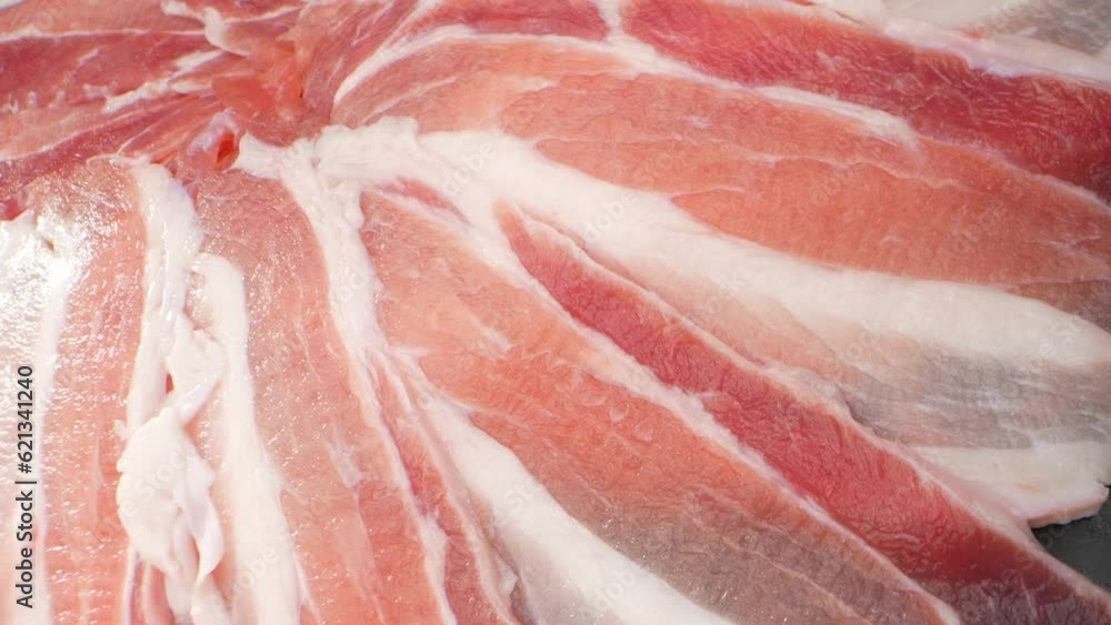 Macro video showcases succulent, raw pork belly slices in exquisite detail. Every tantalizing texture and marbled layer is magnified, inviting a feast for the eyes and igniting a carnivorous craving.
Macro video showcases succulent, raw pork belly slices in exquisite detail. Every tantalizing texture and marbled layer is magnified, inviting a feast for the eyes and igniting a carnivorous craving.