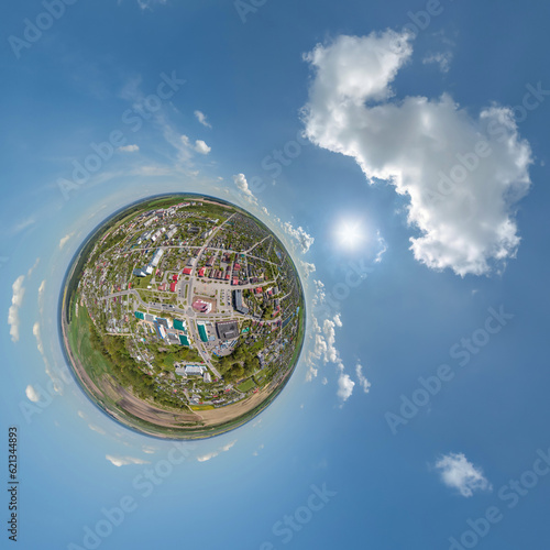 tiny planet in sky with clouds overlooking old town  urban development  historic buildings and crossroads. Transformation of spherical 360 panorama in abstract aerial view.
