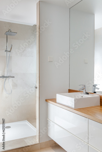 Luxury chrome shower  sink and mirror in modern marble bathroom with natural light for relaxing moments