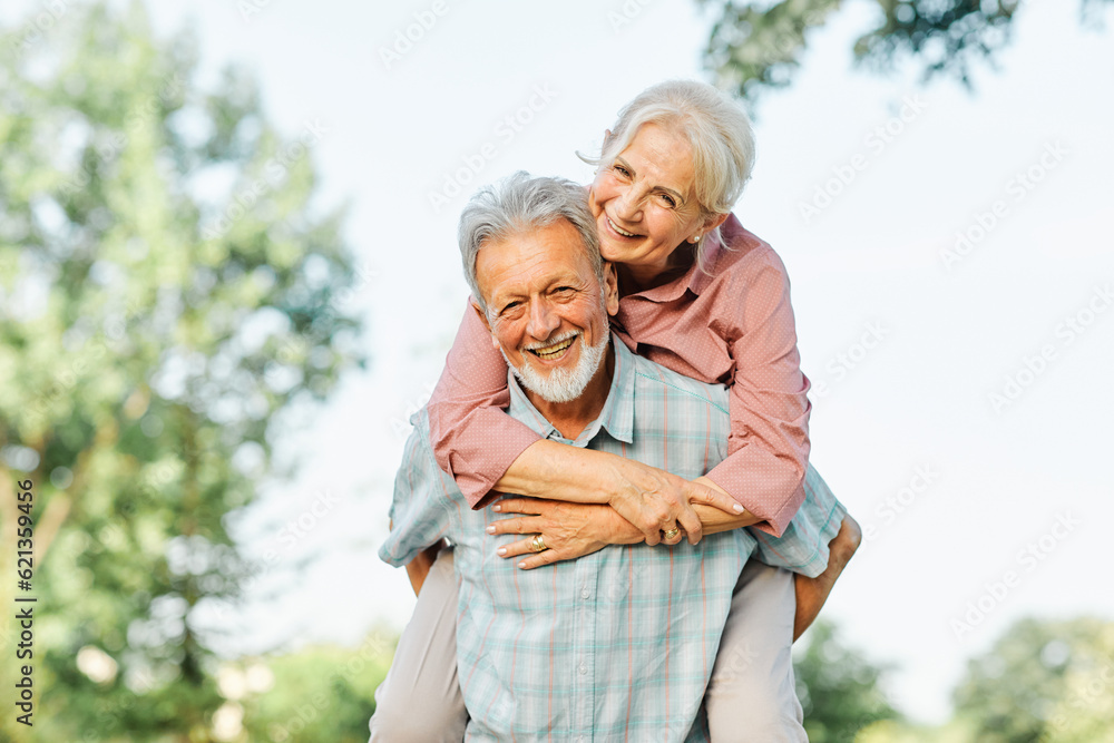 woman man outdoor senior couple happy lifestyle retirement together smiling love fun elderly active vitality nature mature portrait piggyback game - obrazy, fototapety, plakaty 