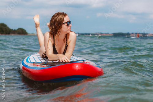 A beautiful young woman sunbathing on a sub in the sea. Summer vacations in the sun.