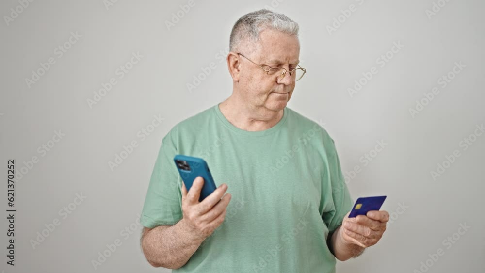 Middle age grey-haired man shopping with smartphone and credit card over isolated white background Middle age grey-haired man shopping with smartphone and credit card over isolated white background