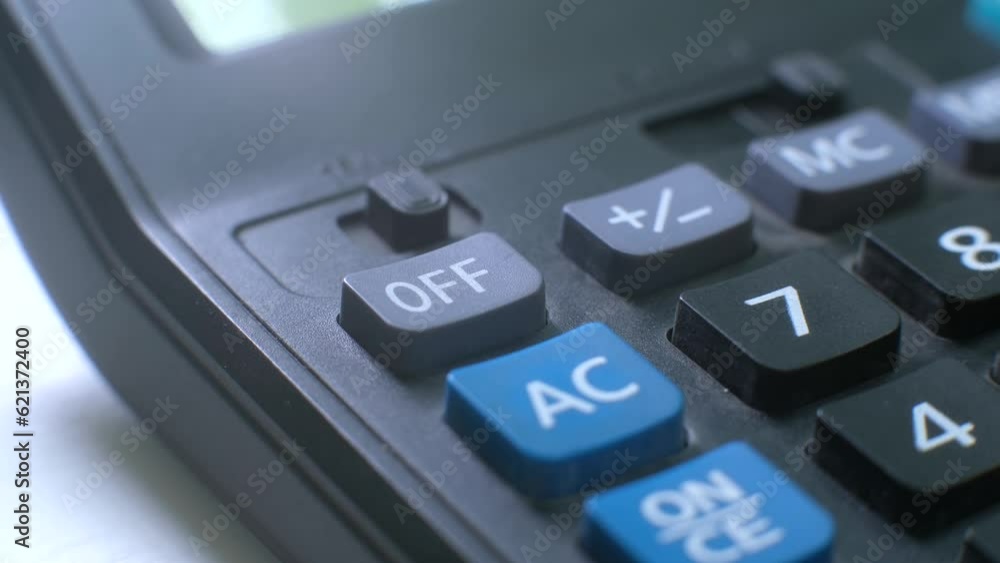 pressing the off button on the calculator with your finger. turn off. close up pressing the off button on the calculator with your finger. turn off. close up