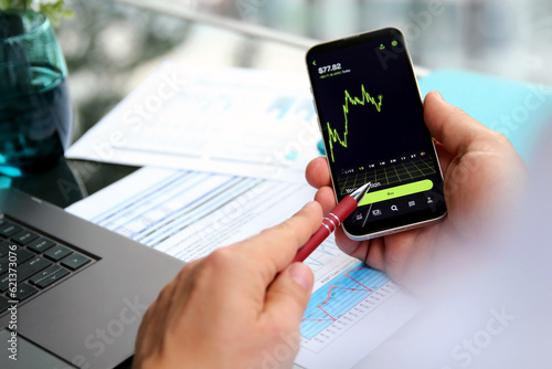 Businessman using a mobile phone for buying a crypto online in the office