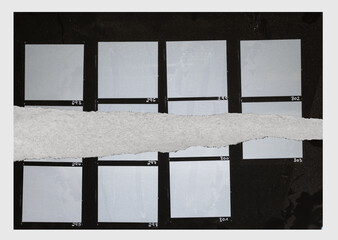real flat bed scan of black and white hand copy contact sheet with empty film frames and torn paper surface.