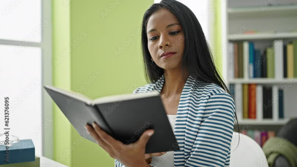 African american woman student reading book sitting on table at library university African american woman student reading book sitting on table at library university