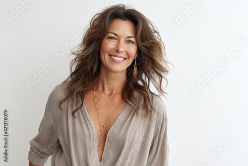 Portrait of beautiful mature woman with long wavy hair smiling at camera