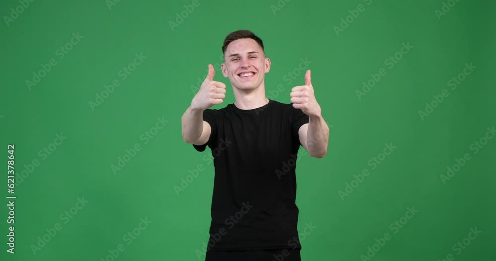 Against a vibrant green background, a Caucasian man enthusiastically extends his hand, displaying a thumbs-up gesture. A broad smile spreads across his face as he expresses his approval. Against a vibrant green background, a Caucasian man enthusiastically extends his hand, displaying a thumbs-up gesture. A broad smile spreads across his face as he expresses his approval.