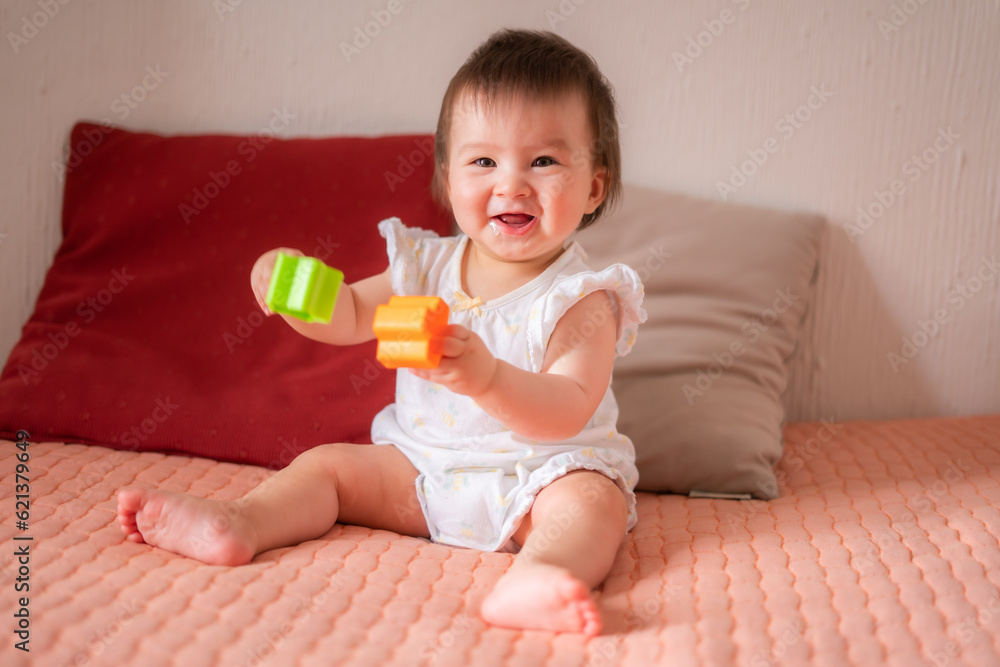 lifestyle home portrait of adorable and beautiful Asian Caucasian mixed baby girl playing on bed with color blocks excited and happy in childhood concept lifestyle home portrait of adorable and beautiful Asian Caucasian mixed baby girl playing on bed with color blocks excited and happy in childhood concept