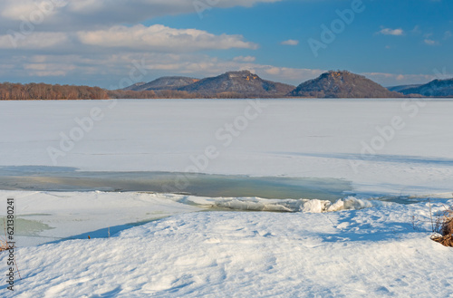 Distant Hills Above a Frozen River photo