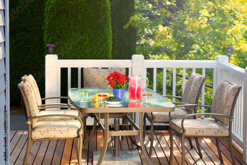 Summer time outdoor breakfast with healthy juice and fruit on outdoor deck table