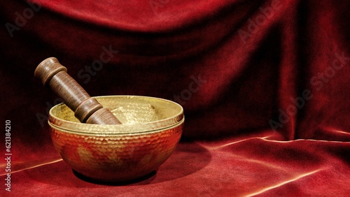 Brass bowl with wooden mallet on red velvet background with right copy space