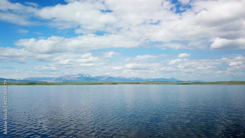 Aerial Panning Shot Of Lake Near Mountain Ranges Against Sky, Drone Flying Forward Over Water - Billings, Montana Aerial Panning Shot Of Lake Near Mountain Ranges Against Sky, Drone Flying Forward Over Water - Billings, Montana