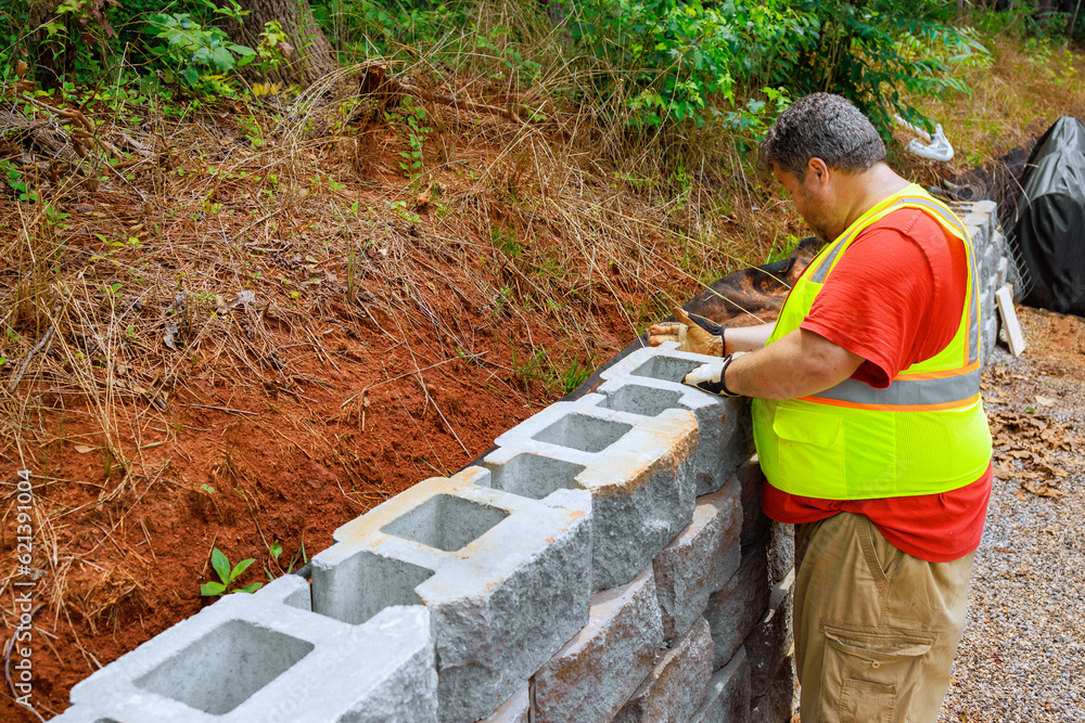 Construction worker was mounting concrete blocks to retaining wall on ...