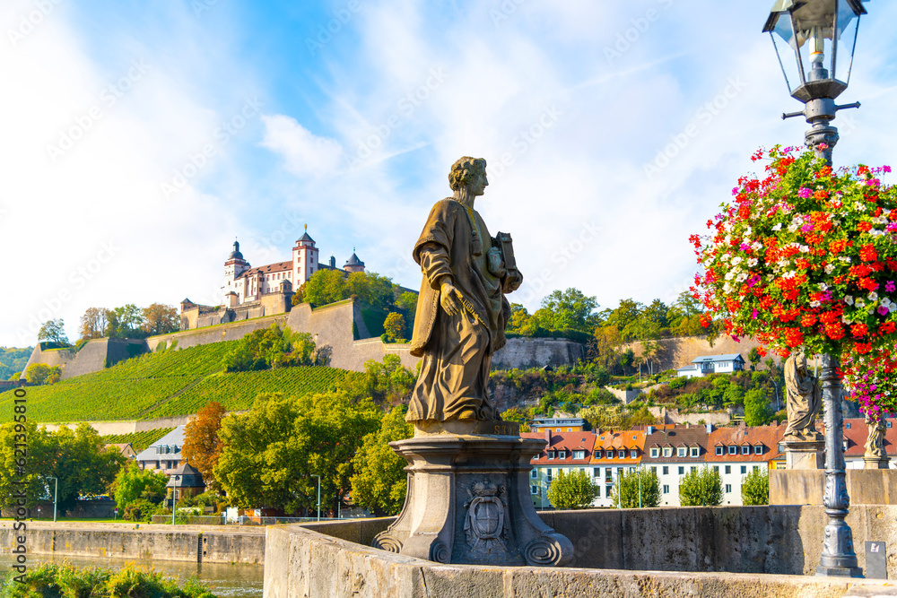 Fototapeta premium View from the Alte Mainbrucke Old Bridge of the medieval Marienberg Fortress along the Main River with the St Colonatus statue in view at the Bavarian town of Wurzburg Germany. 