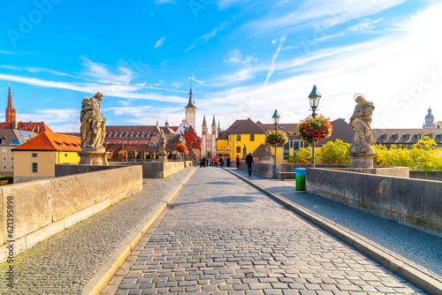 The Old Main bridge or Mainbrücke, with statues of holy figures and the the towers Grafeneckart and St. Kiliansdom, in the Bavarian city of Würzburg, Germany.