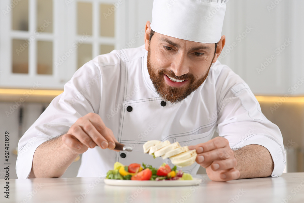 Professional chef adding mozzarella into delicious salad at marble table in kitchen Professional chef adding mozzarella into delicious salad at marble table in kitchen