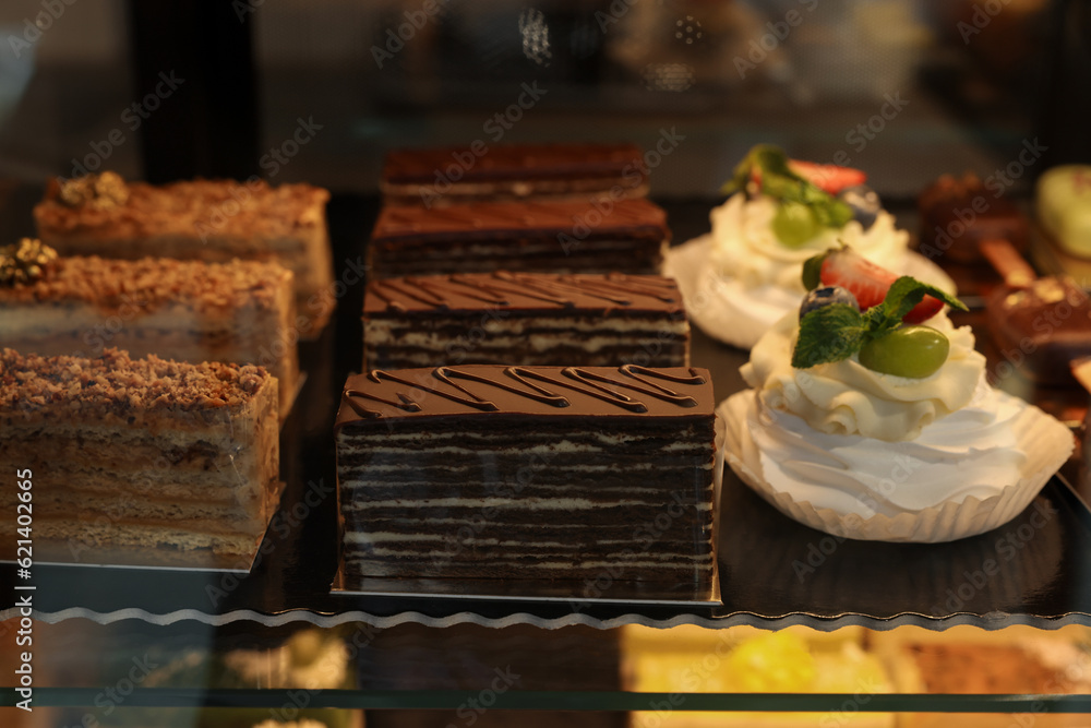 Different tasty desserts on counter in bakery shop, closeup