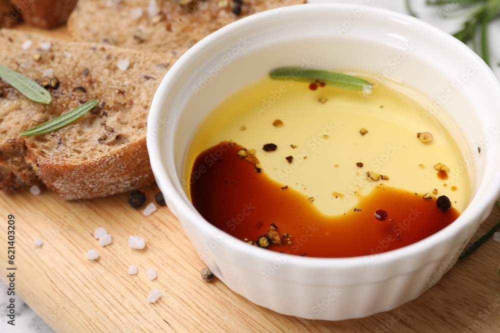 Bowl of organic balsamic vinegar with oil, bread slices and spices on wooden board, closeup Bowl of organic balsamic vinegar with oil, bread slices and spices on wooden board, closeup