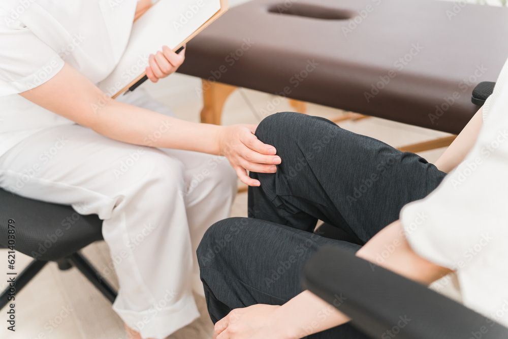 病院・整形外科で脚・膝の怪我のリハビリ・診察をするアジア人女性医師・理学療法士・看護師と患者
