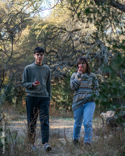 two friends walking at dusk in the forest eating apples © Lucas