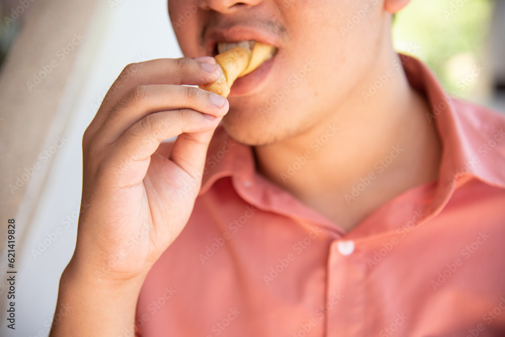 A young man is eating and enjoy his food. A young man is eating and enjoy his food.
