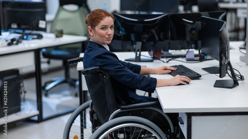 Caucasian smiling woman in wheelchair at work desk. Caucasian smiling woman in wheelchair at work desk.