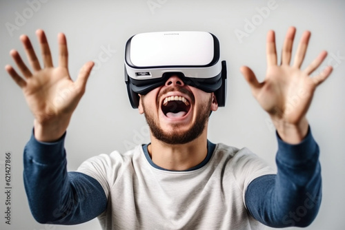 Portrait of a young man using virtual reality headset over gray background