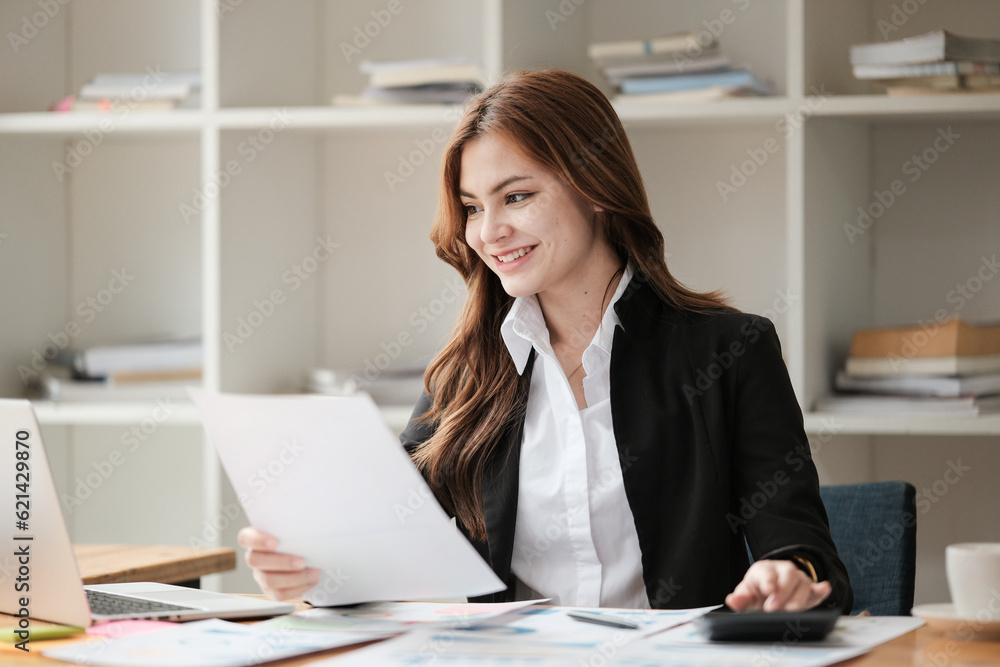 Asian Business woman using calculator and laptop for doing math finance on an office desk, tax, report, accounting, statistics, and analytical research concept Asian Business woman using calculator and laptop for doing math finance on an office desk, tax, report, accounting, statistics, and analytical research concept