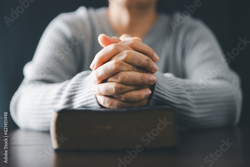 Woman engaged in prayer. In the quiet darkness of a sacred room, she seeks solace, spiritual connection. Immerse yourself in the tranquility and mindfulness of this profound moment.